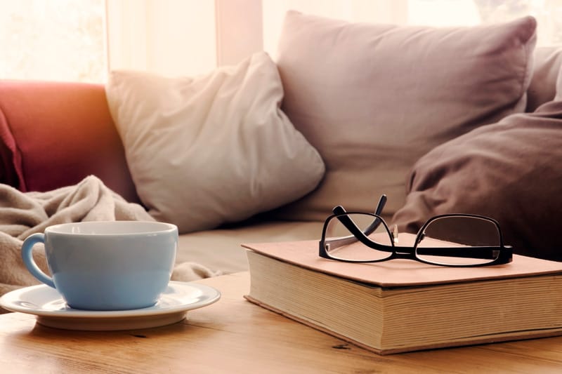 Book and coffee on table by sofa